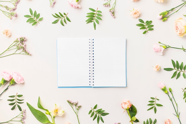 Cuaderno en medio de flores y hojas