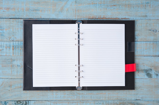 Cuaderno en la mesa de madera azul