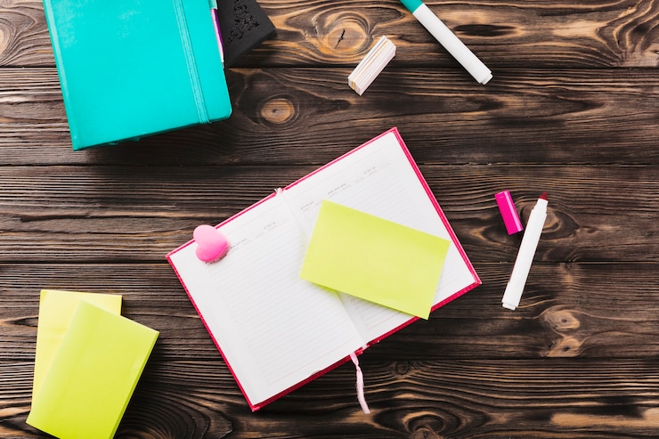 Foto gratuito cuaderno con notas adhesivas y goma