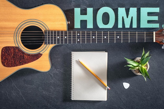 Foto gratuita cuaderno de notas de guitarra acústica y palabra decorativa para el hogar vista superior