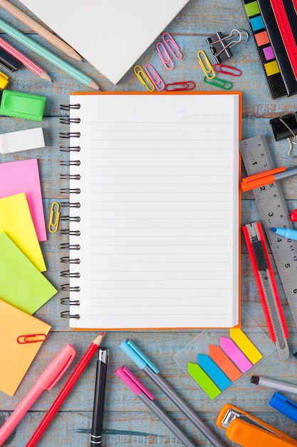 Cuaderno de papel y la escuela u oficina de herramientas en tabla de madera de época