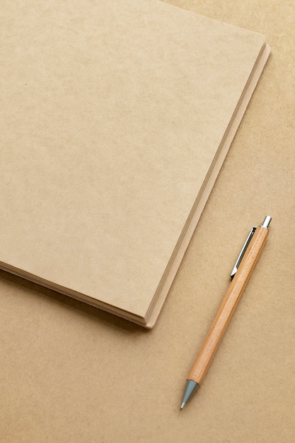 Cuaderno de papel marrón natural con lápiz