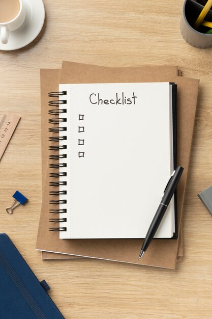 Cuaderno plano con lista de tareas pendientes en el escritorio