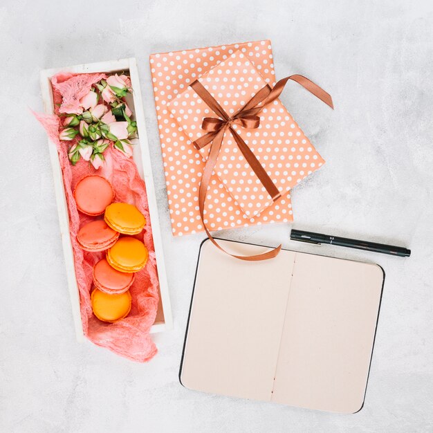 Cuaderno y pluma cerca del postre y presenta