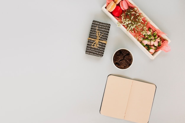 Cuaderno y presente cerca del delicioso postre