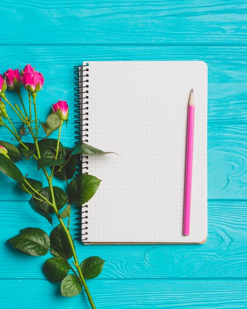 Cuaderno de primer plano cerca de rosas