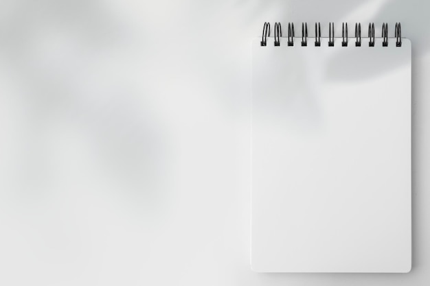 Foto gratuita cuaderno rayado blanco en blanco sobre una mesa blanca