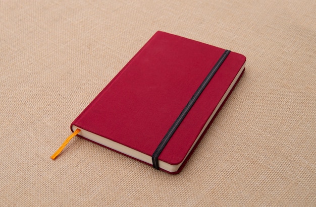 Cuaderno rojo sobre superficie de tela