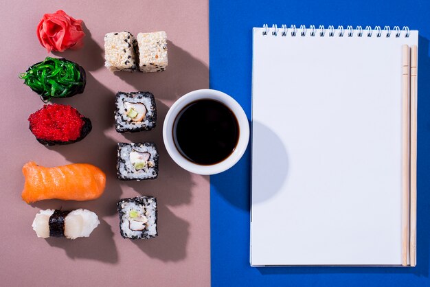 Cuaderno con rollos de sushi al lado