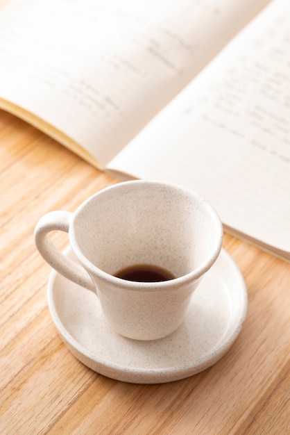 Cuaderno y taza de café de alto ángulo