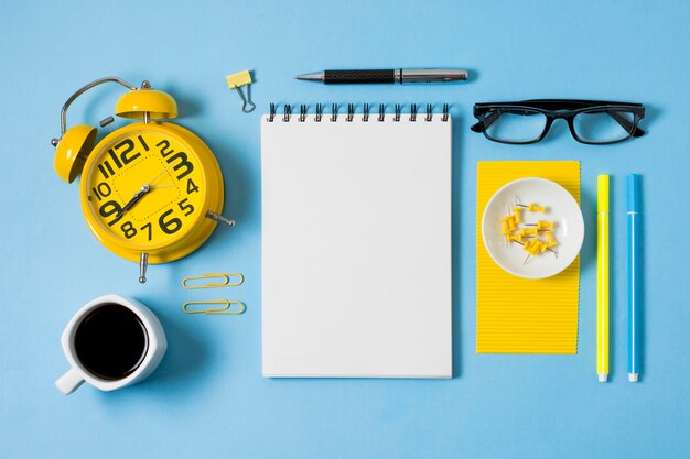 Cuaderno y taza de café plana.