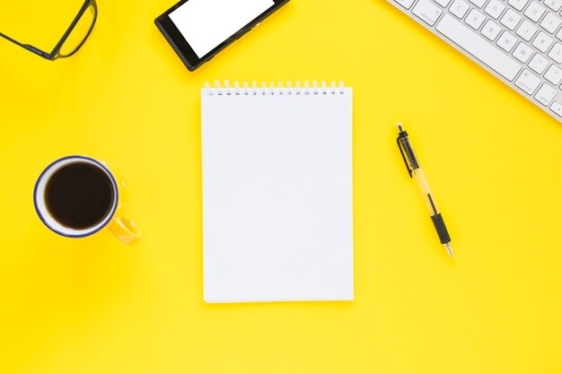 Cuaderno con taza y pluma en escritorio colorido