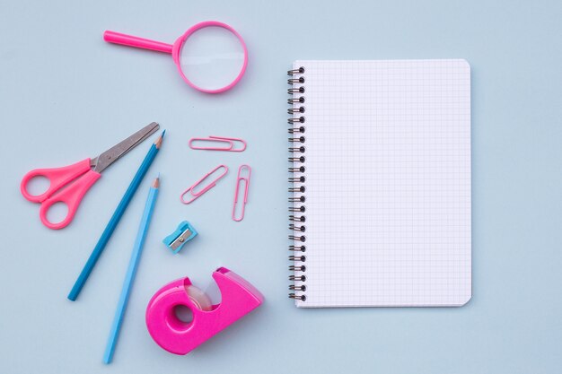 Cuaderno vacío con hermosos elementos para volver a la escuela sobre fondo azul claro