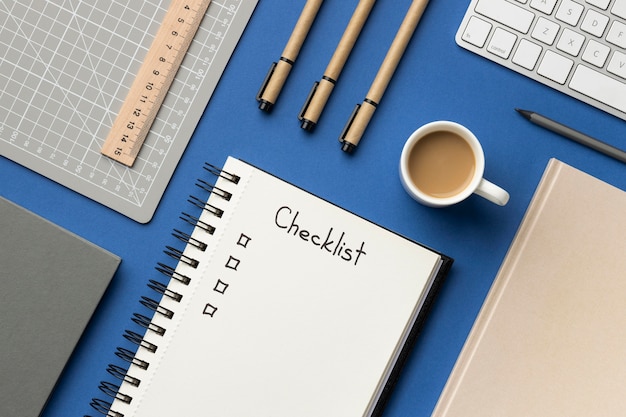 Cuaderno de la vista superior con lista de comprobación en el escritorio