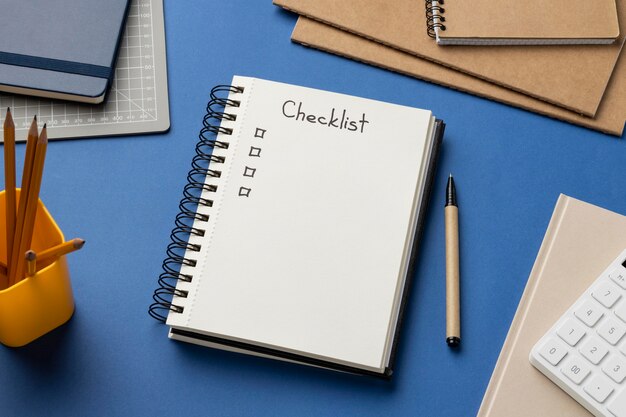 Cuaderno de vista superior con lista de verificación en el escritorio