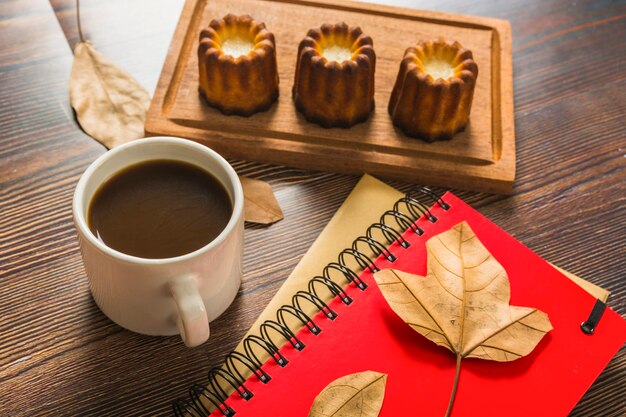 Cuadernos y café cerca de pastelería