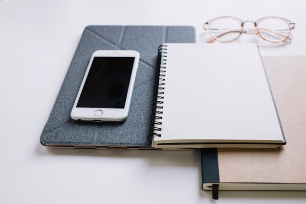 Cuadernos cerca de gafas y teléfonos inteligentes