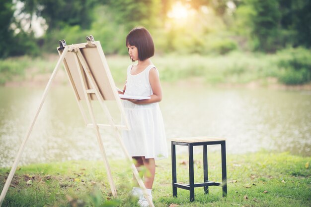 Cuadro de niña artista pintura en el parque