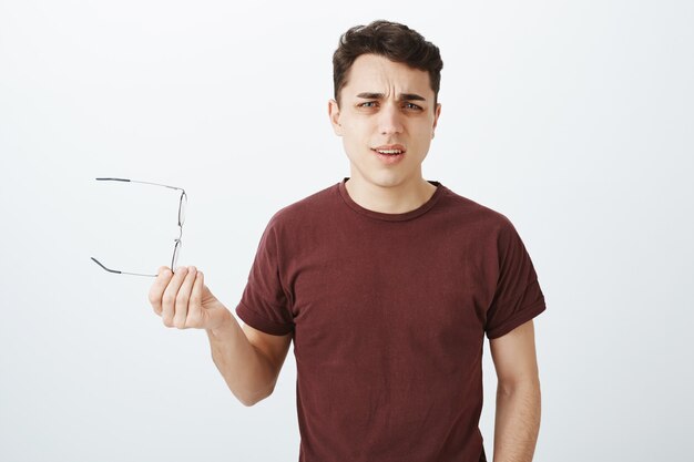 Cuál es tu punto. Retrato de chico adulto guapo molesto frustrado en camiseta roja