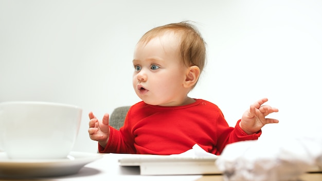 Foto gratuita ¿cuántos documentos puedo firmar niño niña sentada con el teclado de una computadora o computadora portátil moderna?