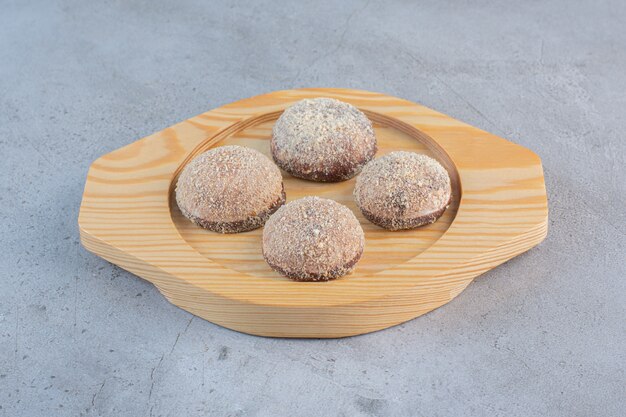 Cuatro sabrosas bolas de trufa colocadas en un plato de madera.