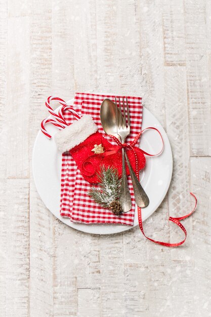 Cubiertos de plata de la vendimia en un plato con decoración de Navidad y nieve en un fondo, vista superior