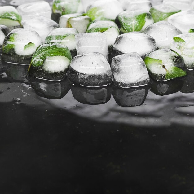 Cubitos de hielo con menta sobre fondo oscuro