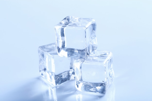 Cubitos de hielo en mesa blanca