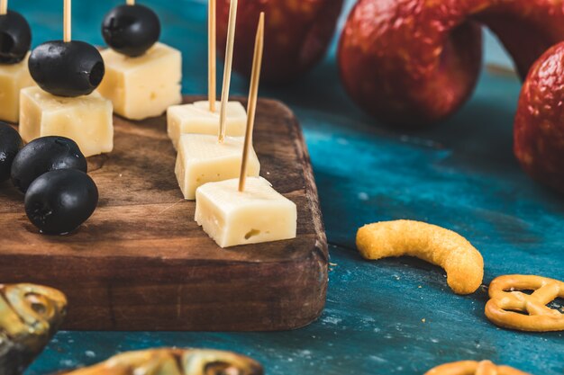 Cubitos de queso con aceitunas negras y otros aperitivos