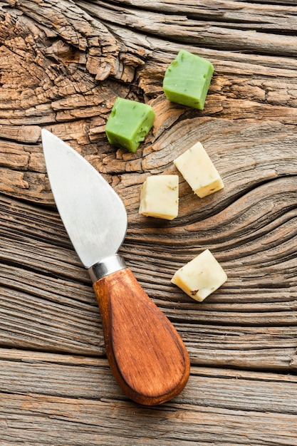 Cubitos de queso con cuchillo en la mesa