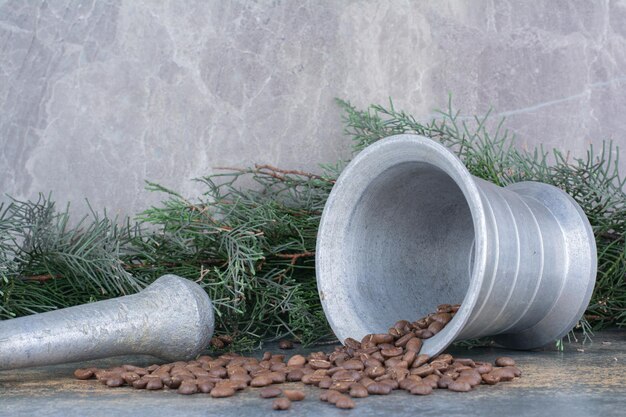 Un cubo de hierro con granos de café sobre fondo de mármol. Foto de alta calidad