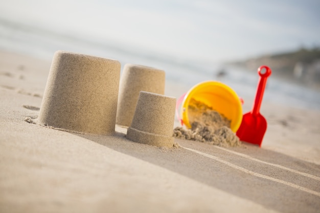 Cubo, pala y castillos de arena en la playa