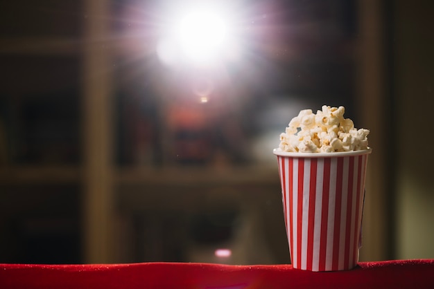 Cubo de palomitas de maíz rayado en el cine