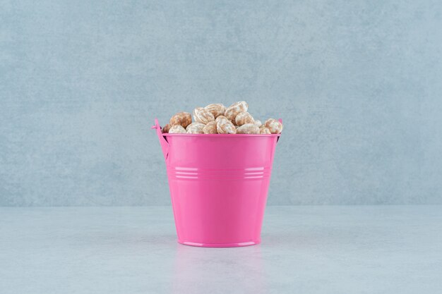 Un cubo rosa lleno de pan de jengibre delicioso dulce sobre fondo blanco. Foto de alta calidad