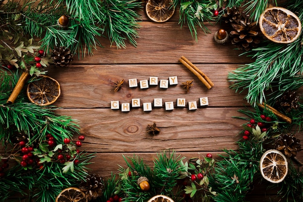 Cubos con letras cerca de ramitas de navidad