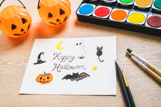 Cubos y pintura cerca del dibujo de Halloween