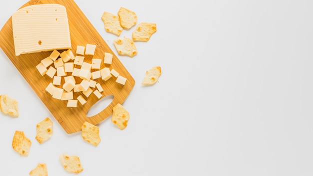 Cubos de queso y galletas aisladas sobre fondo blanco