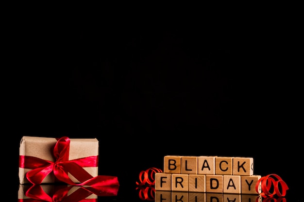 Foto gratuita cubos de viernes negro con presente sobre fondo negro