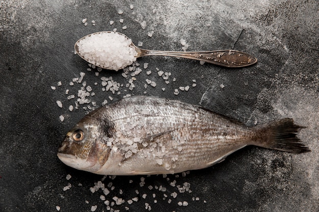 Cuchara de anuncio de pescado de marisco crudo con sal marina