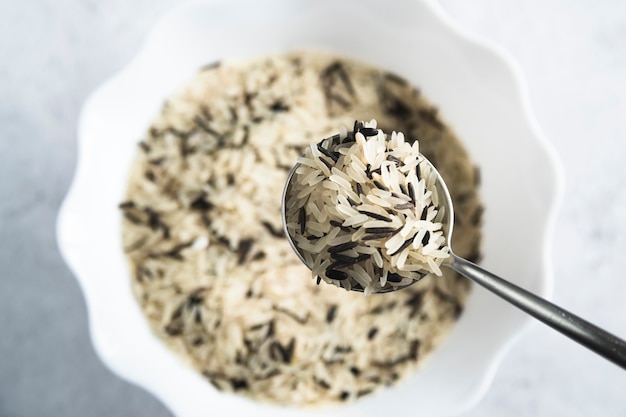 Foto gratuita cuchara con arroz blanco y negro cerca de tazón