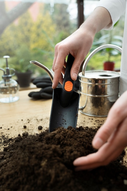 Foto gratuita cuchara de jardinería de mano de alto ángulo