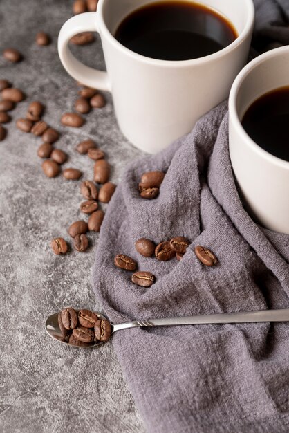 Cuchara llena de granos de café y tazas