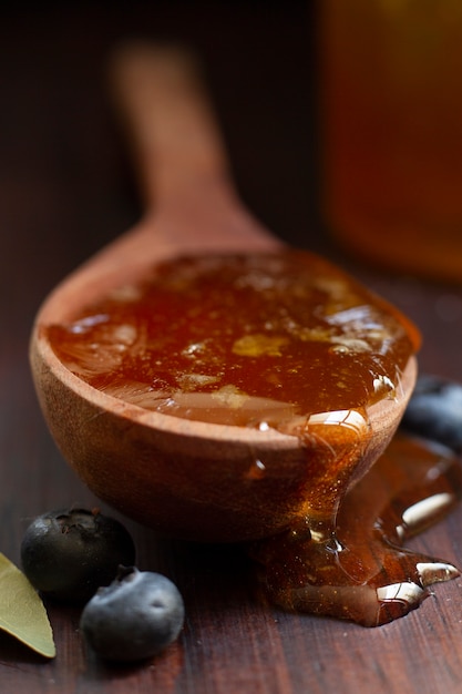 Foto gratuita cuchara de madera con miel y arándanos