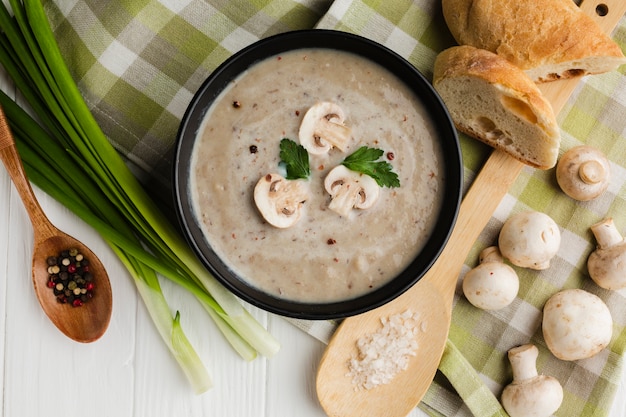 Cuchara de madera plana y sopa de champiñones con pan y champiñones