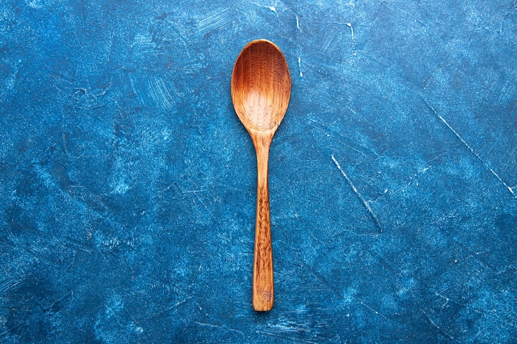 Foto gratuito cuchara de madera de vista superior en lugar de copia de mesa azul