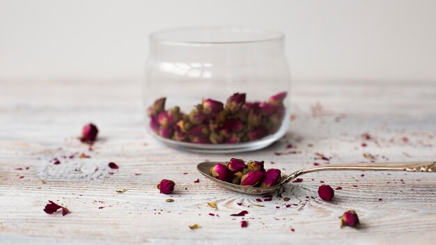 Cuchara de primer plano con mini rosas aromáticas