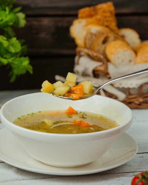 Foto gratuita cuchara con sopa de pollo con verduras y eneldo