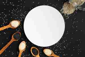 Foto gratuita cucharas de vista superior con semilla y círculo blanco