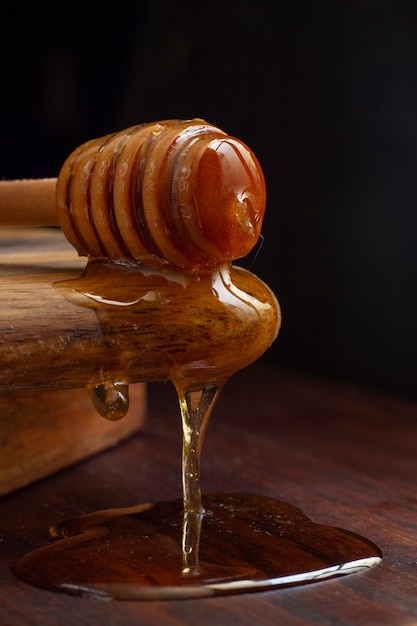 Cucharón de miel de madera con goteo de miel