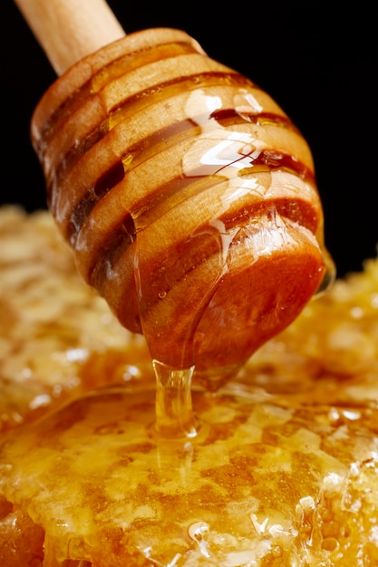 Cucharón de miel de madera con panal y cera de abejas